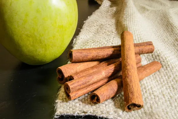 Ahşap bir masa üzerinde kumaş üzerine tarçın baharat