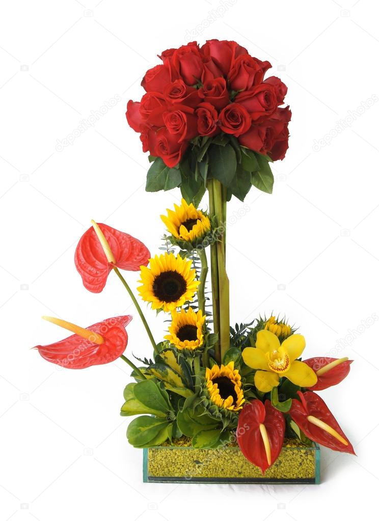 Glass pot with red roses and sunflowers on white background