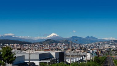 Kuzey Quito şehrinin panoramik manzarası. Arka planda Cotopaxiy volkanı Pasochoa volkanı var. Açık bir sabah mavi gökyüzü ile birlikte.
