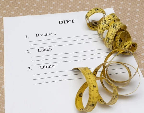 Papel con plan de dieta y rollo cinta métrica amarilla —  Fotos de Stock