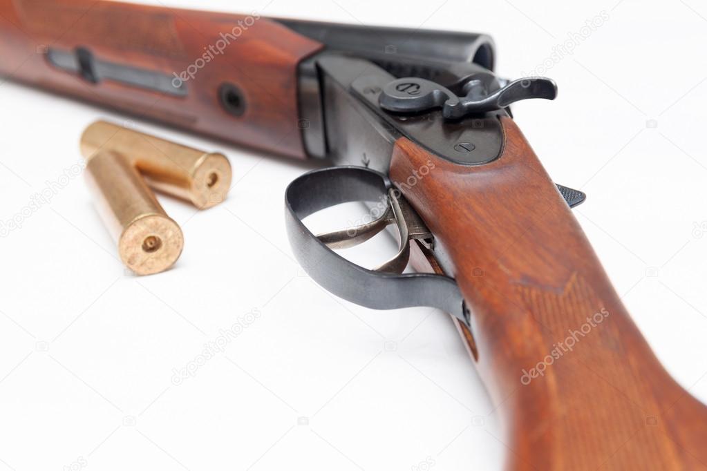 Opened double-barrelled hunting gun with bullets isolated on white 