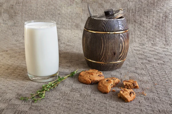 Vaso de leche, galletas, tomillo y madera de miel sobre la mesa — Foto de Stock