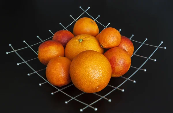 Τα πορτοκάλια σε μεταλλική πλάκα σε μαύρο φόντο — Φωτογραφία Αρχείου