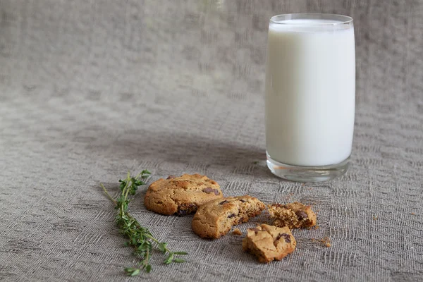 Un vaso de leche, dos galletas, tomillo sobre la mesa — Foto de Stock