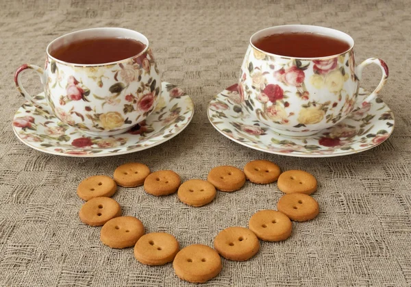 Dos tazas de té y algunas galletas en la mesa — Foto de Stock