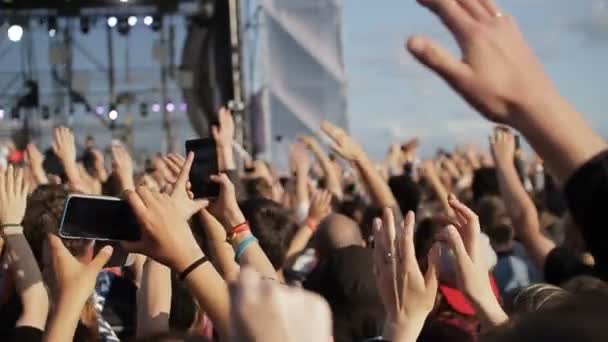Le persone alzano le mani e applaudono ad un concerto . — Video Stock