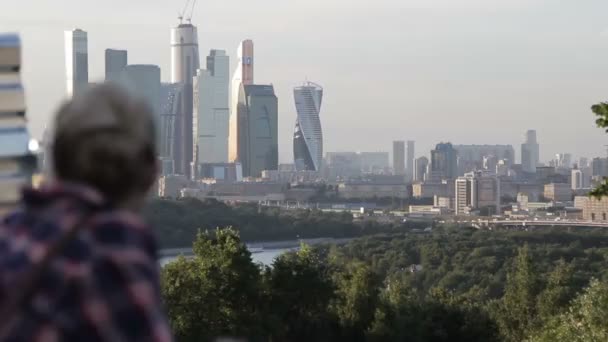 Meisje kijkt naar de stad. Panorama van de stad — Stockvideo