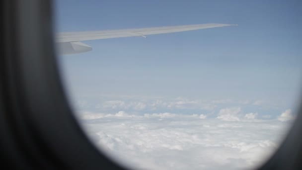 Wing of passenger airplane. the view through the window. above the clouds — Stock Video