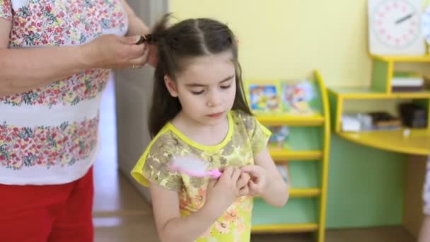 Coiffure d'enfant. Coiffeur fait coiffure avec des cheveux tressés . — Video