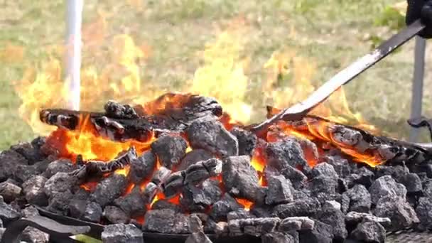 Un herrero modela una barra de hierro con martillo después de tomarla de la fragua de fuego . — Vídeo de stock