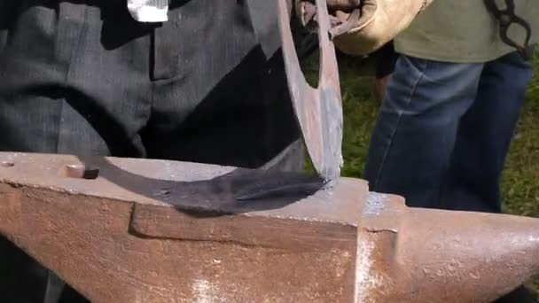 Коваль моделює брусок заліза з молотком після того, як взяв його з вогню кузня . — стокове відео