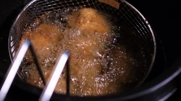 Slagman-gebakken kip vlees nuggets zijn alle diepe gebakken goed gedaan in hete kokende olie pan. — Stockvideo