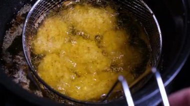 Meyilli kızarmış tavuk eti nuggets tüm derin kızarmış Aferin içinde sıcak kaynar yağ tavası vardır.