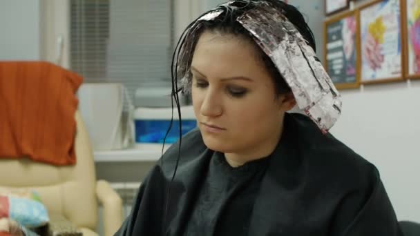 Jeune femme lisant un magazine dans un salon de coiffure — Video