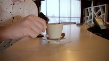 adam el ahşap bir masa üzerinde latte ile