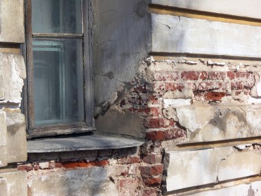 Kırmızı tuğla ile binanın harap sıva duvar eski penceresinde