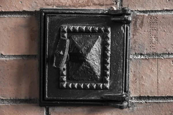 Boki pieca żelaza czarny drzwi na ścianie pieca z czerwonej cegły — Zdjęcie stockowe