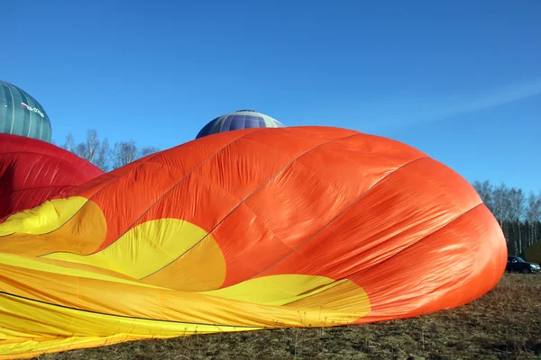 Oranje ballon ligt op de grond - proces voor het oppompen van de bal — Stockfoto