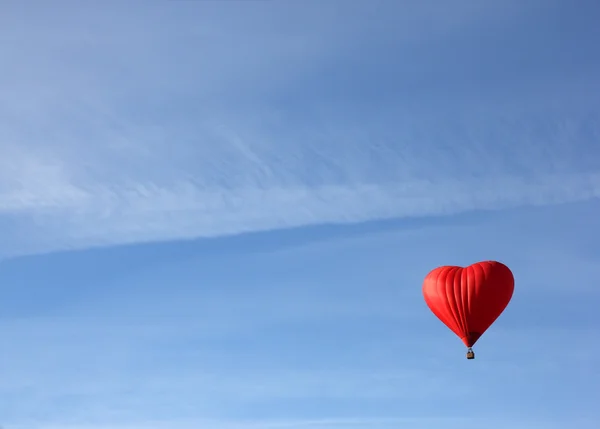bir kırmızı kalp şeklinde kırmızı balon açık mavi sk