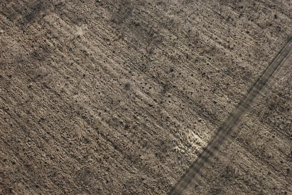 Вид на весняно-коричневе вирощене поле і дорогу з вигляду на птахів — стокове фото