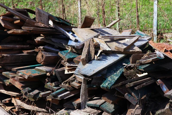 A pile of debris and old broken wooden boards after demolition o — Stock Photo, Image