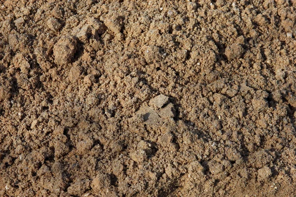 Obehandlad våt stenbrottet grova brun sand förgrunden närbild — Stockfoto