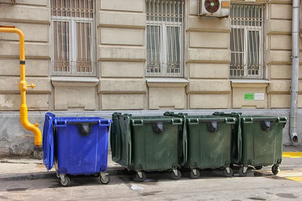 4 niebieski i zielony kolor plastikowe dumpsters na n ulicy miasta — Zdjęcie stockowe