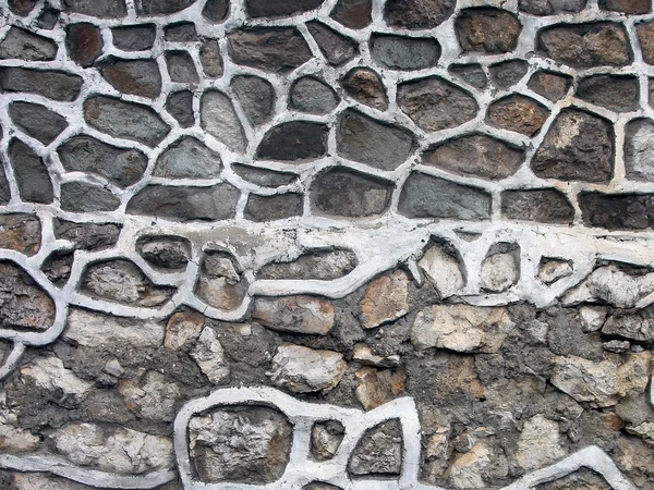 Muro in muratura di pietra da vecchie macerie squallide fatiscenti con grande w — Foto Stock