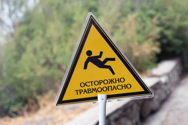 Signo amarillo triangular con la inscripción precaución traumático y im — Foto de Stock