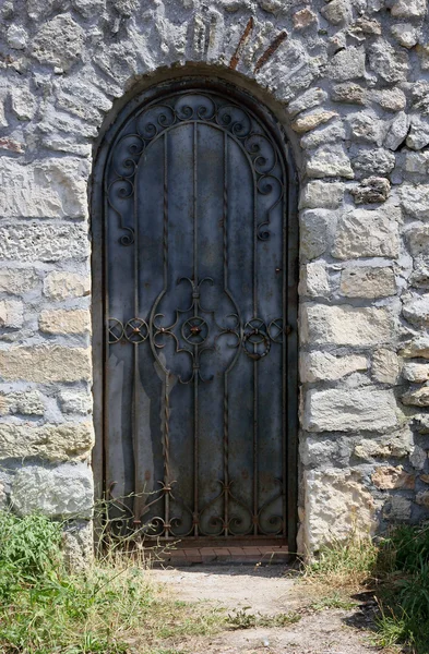 瓦礫の壁にアンティークの古い錬鉄のドア — ストック写真