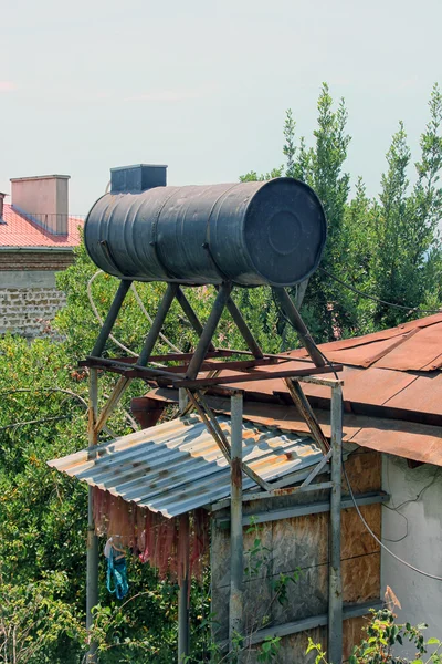 克里米亚屋顶上的大黑色金属圆形水箱 — 图库照片