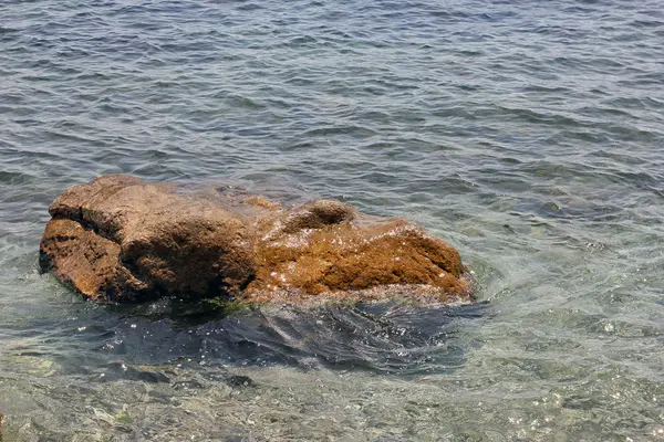 Bella bagnato brillante piccola roccia di pietra in blu limpido Mar Nero w — Foto Stock