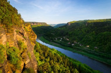 Elbe Kanyonu 'ndaki Elbe Nehri manzaralı akşam güneşinde kum taşı oluşumları ve ormanları..