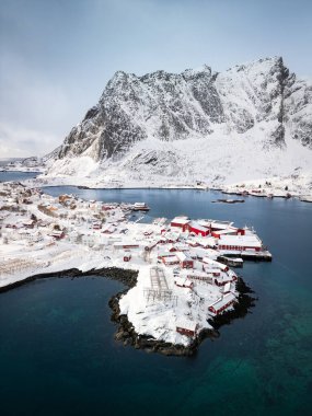 Kışın Reine balıkçı köyünün havadan görünüşü. Kuzey Norveç manzarasında tipik kırmızı kulübeler.