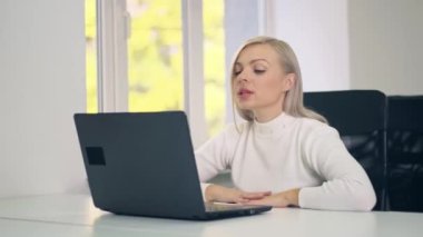 Milenyum kadını evde bilgisayarla görüntülü konuşma yapıyor. İş kadını bilgisayarı kullanarak video iletişimi kuruyor. Çevrimiçi eğitim ya da mesafe çalışması.