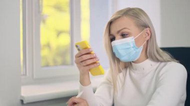 Coronavirus önleme için koruyucu maske takan kadın. Stylus 'la birlikte karantinada cep telefonu kullanan bir iş kadını. Salgın virüs krizi sırasında çalış