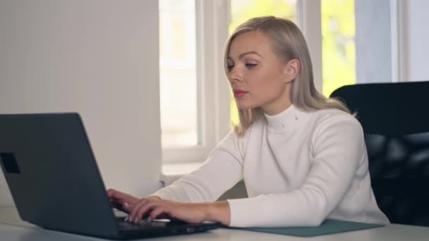 一位自信的女商人坐在她的办公桌前 在总公司的笔记本电脑上工作 时尚漂亮的女人在笔记本电脑上打字找工作 — 图库视频影像