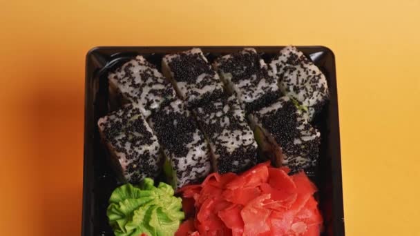寿司棒は黒い箱からキャビア 米およびアボカドとロールを取る 寿司屋 アジア料理 日本料理の配達 — ストック動画