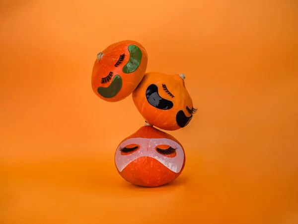 Trzy Dynie Przepaskami Oczy Maska Twarz Ręcznik Pomarańczowym Tle Przestrzeń — Zdjęcie stockowe