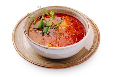 Bir kase zengin ve lezzetli domates çorbası kırsal bir tabakta duruyor. Taze bitkiler üzerinde yüzer, renk ve aroma ekler. Bu yemek serin bir günde sıcak bir yemek için mükemmel..