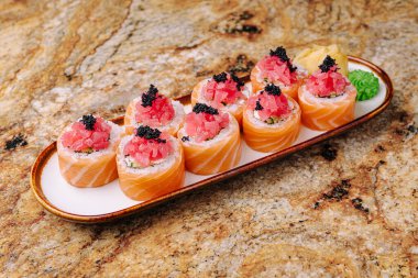 Taze suşi dürümleri, Japon mutfağının sanatsal bir sunumunu sunan ton balığı, havyar ve wasabi gibi canlı malzemelerle servis edilir..