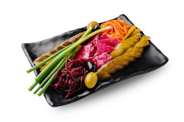 Canlı bir tabakta, siyah servis tabağında çeşitli sebze turşusu bulunur. Yeşil soğan, turşu havuç renk ve cazibe ekler..