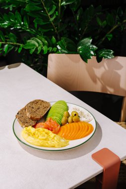 Avokado, omlet, somon, ekmek ve peynirli sağlıklı bir kahvaltı.