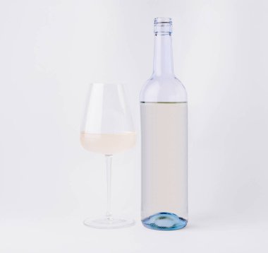 Beyaz şarapla dolu berrak bir şişe kısmen aynı şarapla dolu bir bardağın yanında duruyor. Basit, şık düzenleme içkinin ferahlatıcı rengini ve kalitesini vurguluyor..