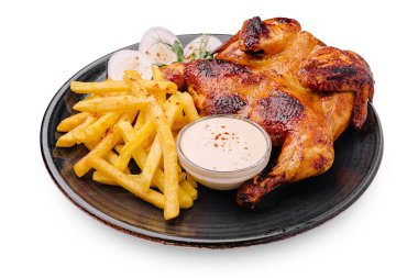 Lezzetli bir tabakta ızgara tavuk ve yanında altın patates kızartması ve kremalı sos var. Yemek, tat vermesi için taze otlarla süslenir..