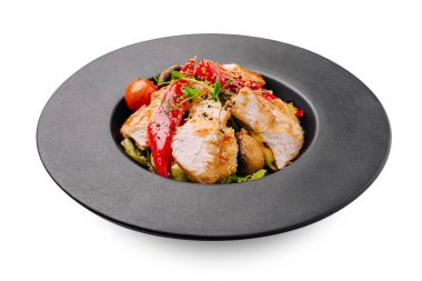 Izgara tavuk, kırmızı biber, kiraz domatesleri ve mantarlar da dahil olmak üzere canlı sebzelerle güzelce kaplıdır. Taze otlar ve susam tohumlarıyla süslenerek renkli bir yemek oluşturulur..