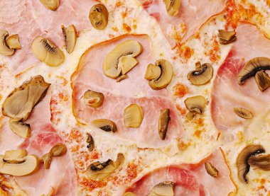 Lezzetli pizza, üzerinde jambon dilimleri ve çeşitli mantarlar olan bol peynirli bir tabaka sunar. Sıradan bir yemek yerinde tadını çıkarmaya hazırdırlar..
