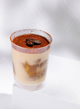 Bu tatlı, berrak bir fincanda kremalı kahve ve kakao katmanları içeriyor. Beyaz bir yüzeyde, basit ama çekici bir tasarım sergiliyor. Kahve sevenler ve tatlı sevenler için mükemmel..