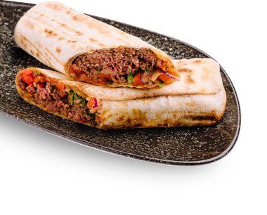 Baharatlı et ve taze sebzelerle dolu lezzetli et paketleri siyah bir tabakta sergilenir. Yemek iştah açıcı görünüyor ve tadını çıkarmaya hazır, hızlı bir öğle yemeği için mükemmel..