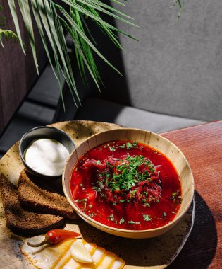 Taze otlarla süslenmiş zengin bir pancar çorbası yanında bir kase siyah ekmek ve küçük bir kase ekşi krema bulunur. Bu sıcak yemek sıcak bir yemek için mükemmel..